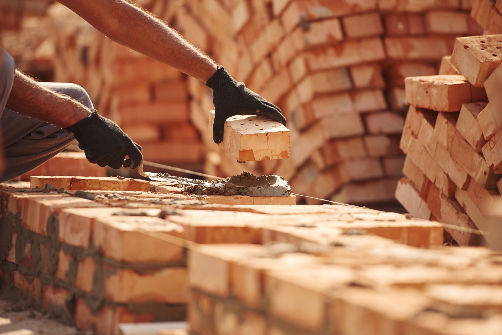 Placing the bricks. Close up view of man that is working on the construction site